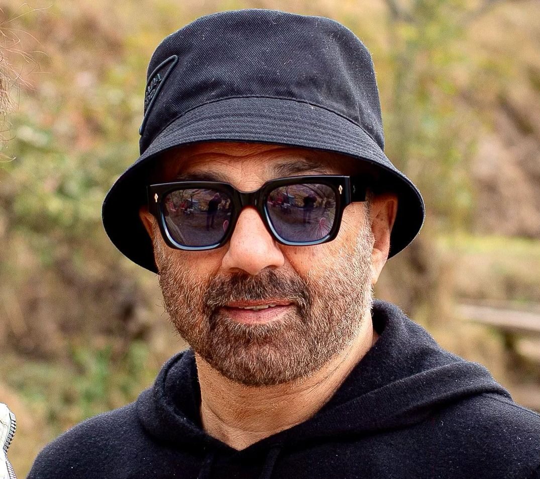 Sunny deol indian actor iamge in black shirt and cap